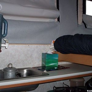 View of water container and sink with bed pulled out