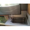 Sink on passenger side beside two person love seat and rear door