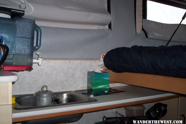 View of water container and sink with bed pulled out